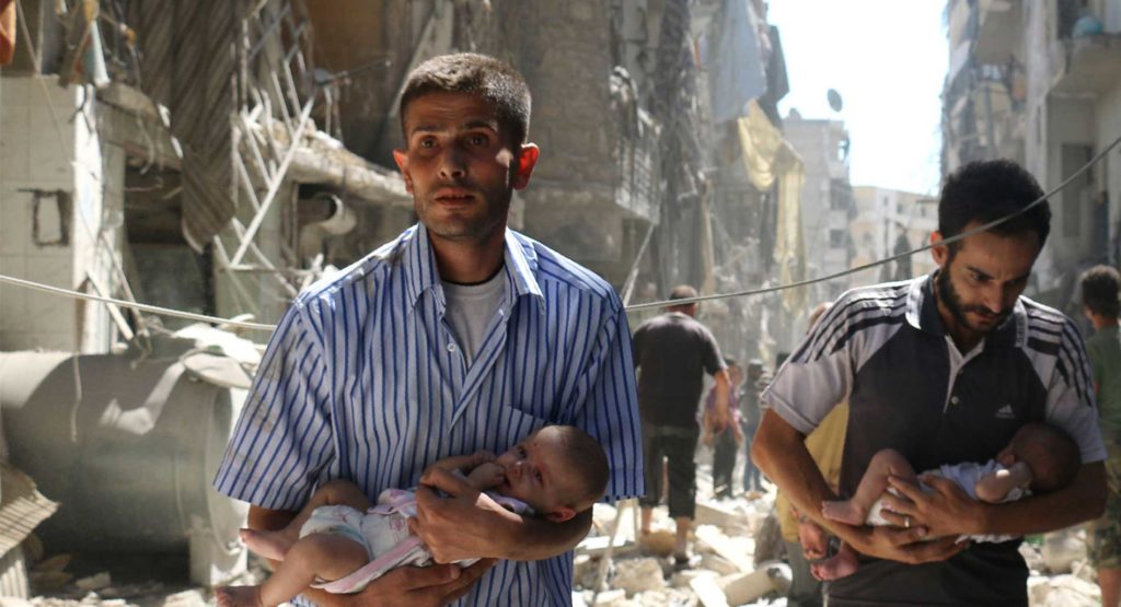 Syrian men carrying babies through the rubble of destroyed buildings in the Salihin neighbourhood of Aleppo in September 2016. © AMEER ALHALBI/AFP/Getty Images