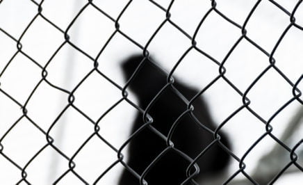A silhouette behind fencing