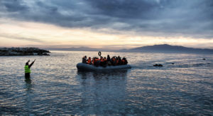Refugees and migrants on an inflatable boat arrive in Greece.