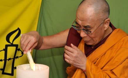 The Dalai Lama lights a candle, one of 30 corresponding to 30 Articles of the Universal Declaration of Human Rights, on World Refugee Day.