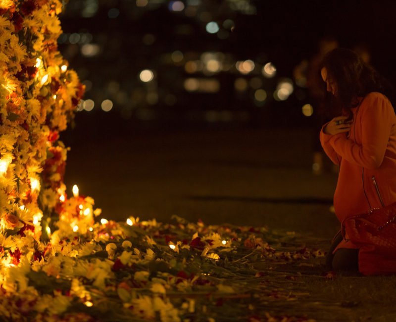 A person kneels in prayer at a #keephopealive vigil in Sydney to end the death penalty