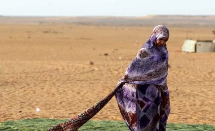 A Sahrawi refugee stands on a rug at the Sahrawi refugee camp of Dakhla