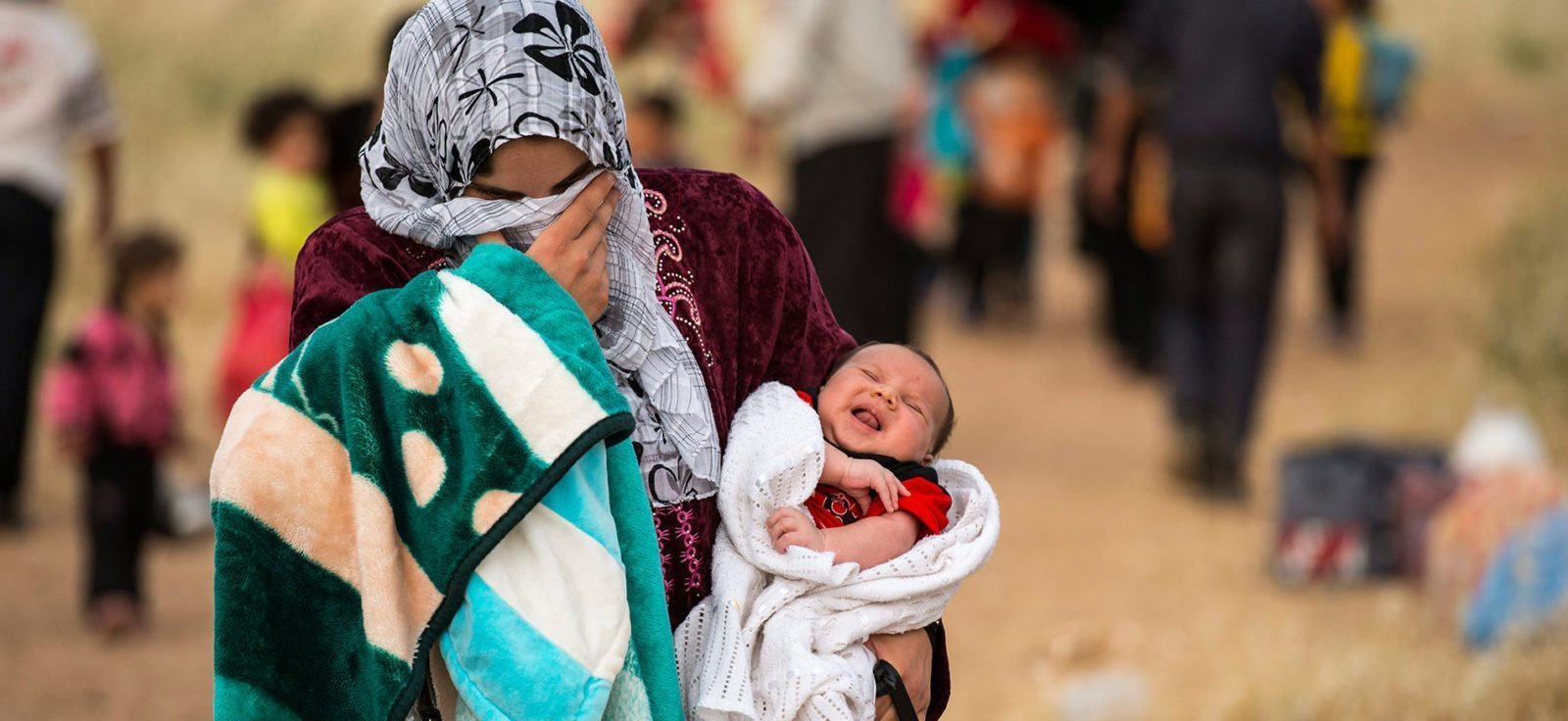 A young mother and refugee carries her baby in search of a safe home