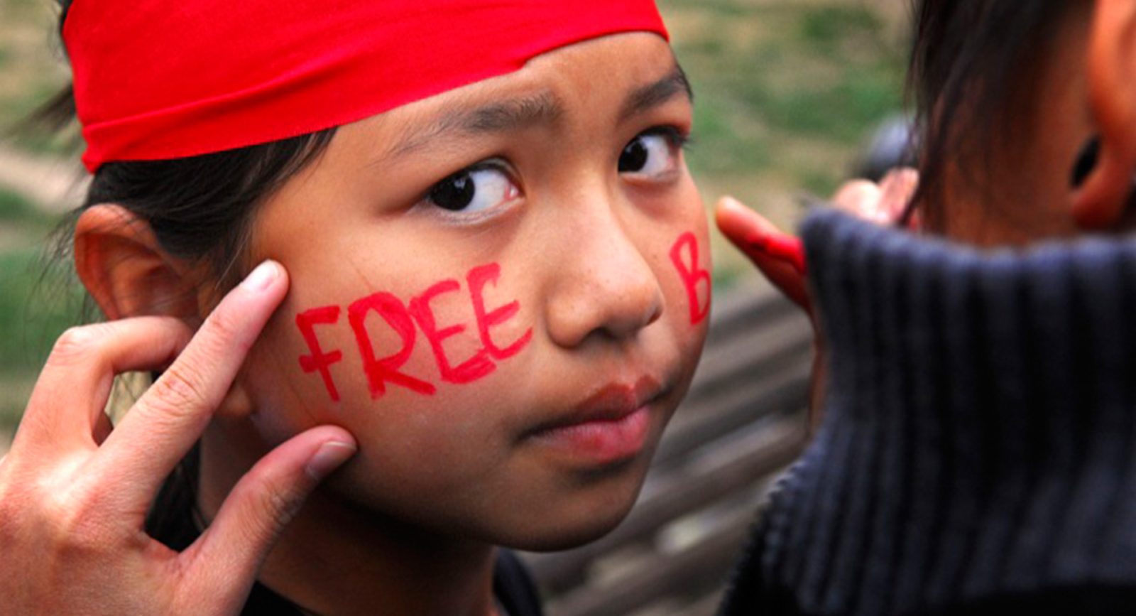 A young girl with 'Free Burma' written across her cheeks