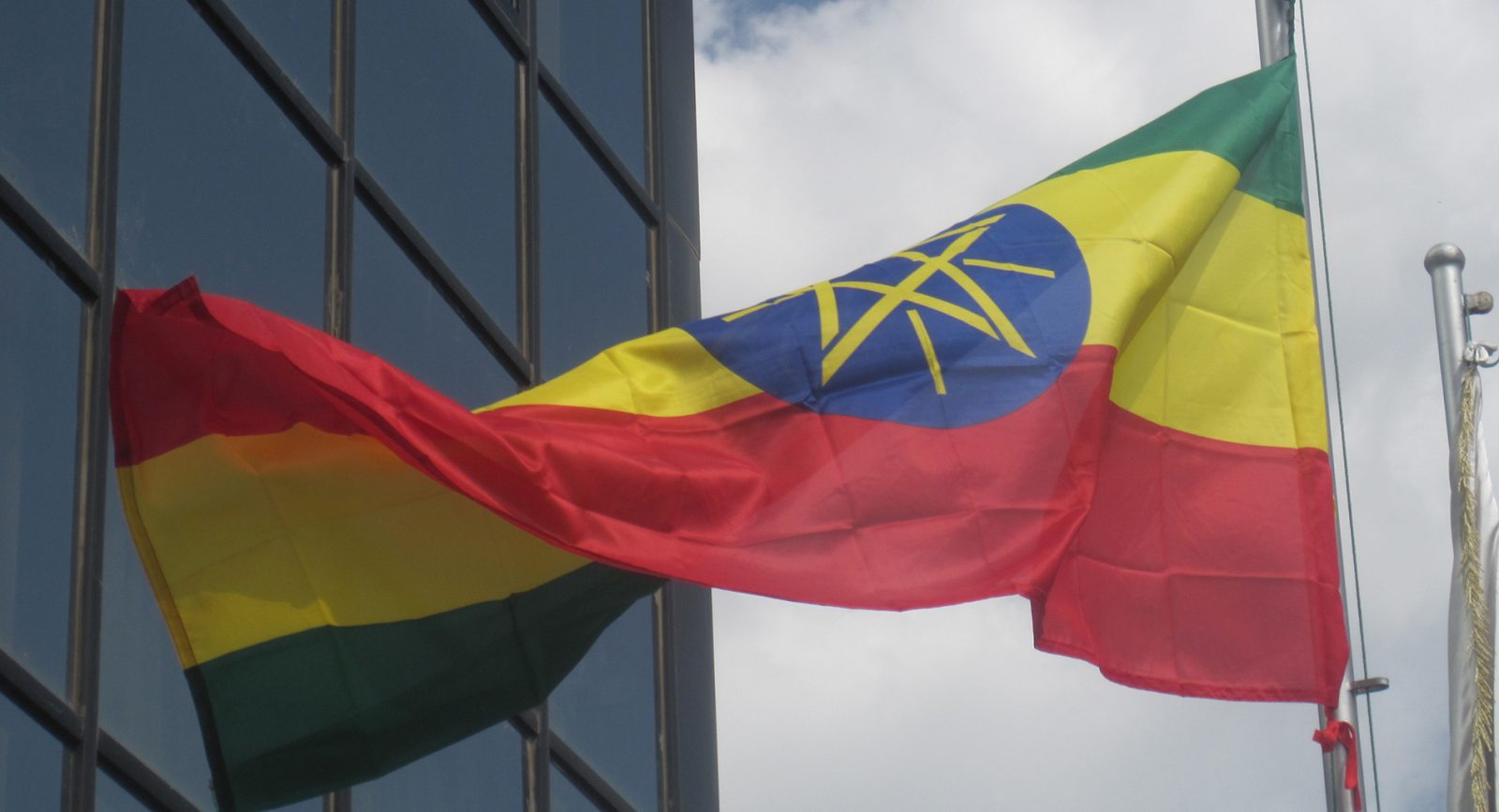 Photograph of the Ethiopian flag flying outside an unidentified official building in the country
