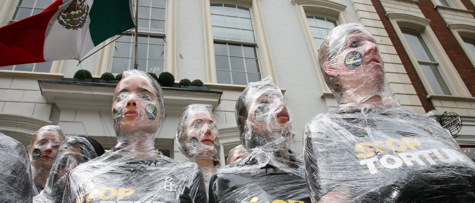 Amnesty activists wrapped in plastic in solidarity with victims of torture in London, 2014.