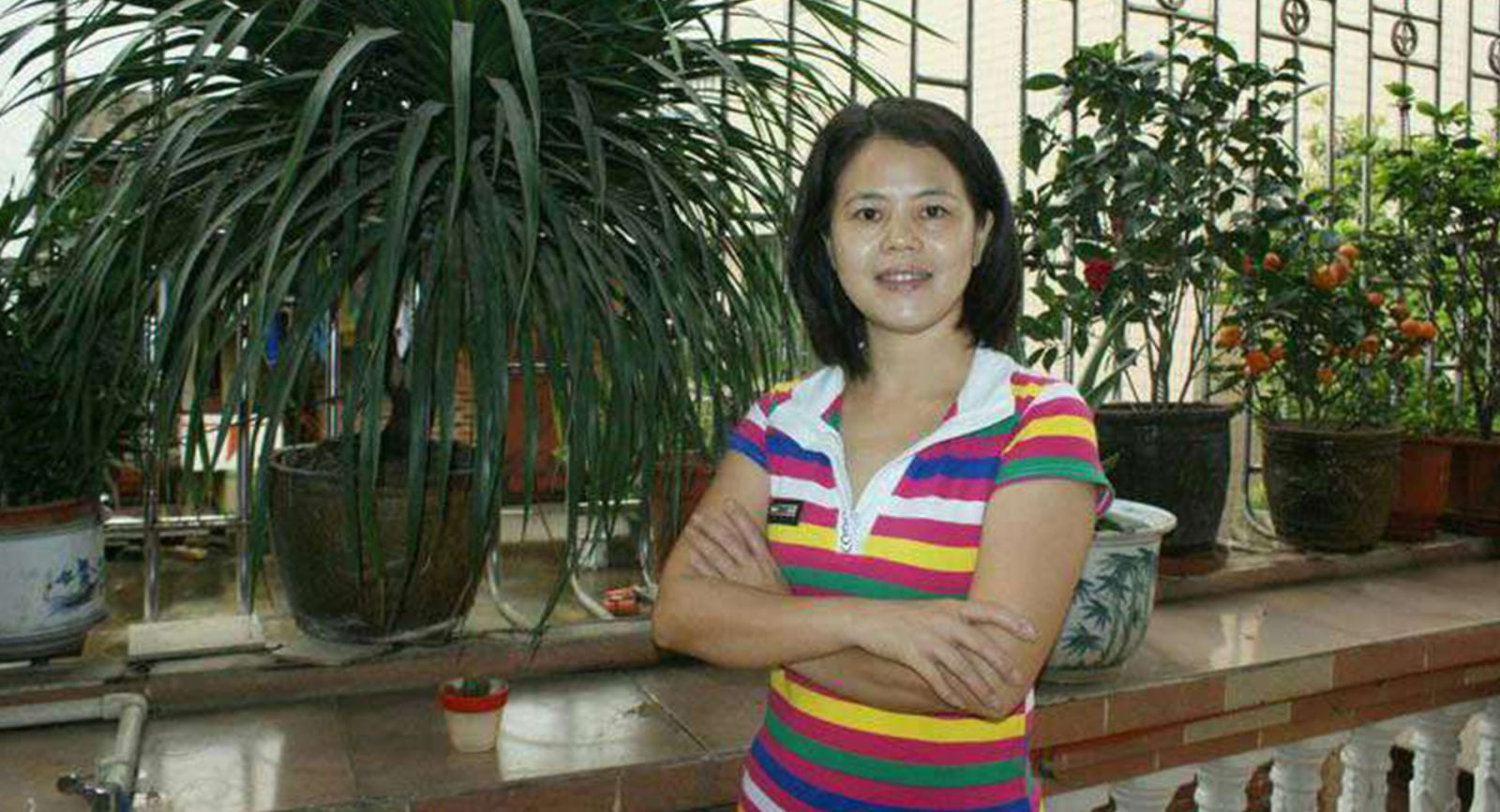 Chinese women's rights activist Su Changlan smiles into the camera with arms crossed