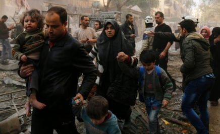Syrians make their way through debris following air strikes in Aleppo, Syria on January 13, 2016.