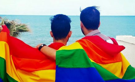 Two people wearing rainbow flags in Tunisia