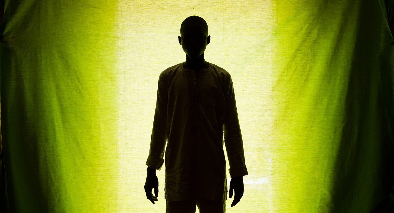 A silhouette of a man against a green background.