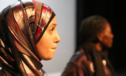 a young woman wearing a hijab on stage