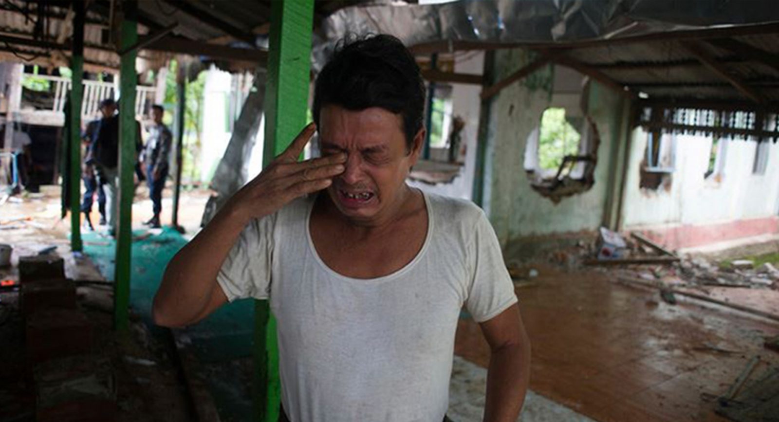 A man cries after a mosque is burned down in Myanmar