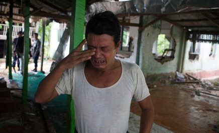 A man cries after a mosque is burned down in Myanmar