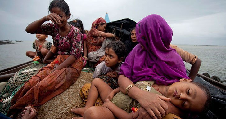 Group of Rohingya refugee women and children on boat at sea