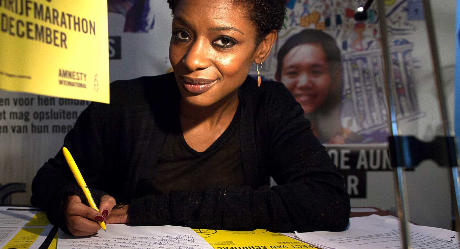 A woman smiling at the camera at a letter writing marathon