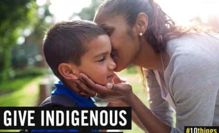 Indigenous woman kissing young Indigenous boy on the cheek