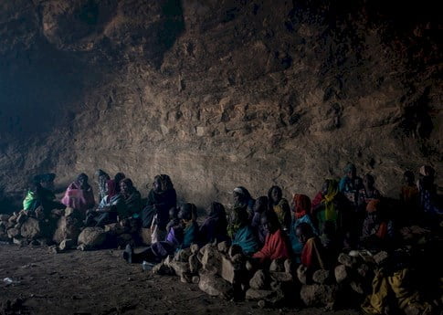 Group of people huddled in a cave