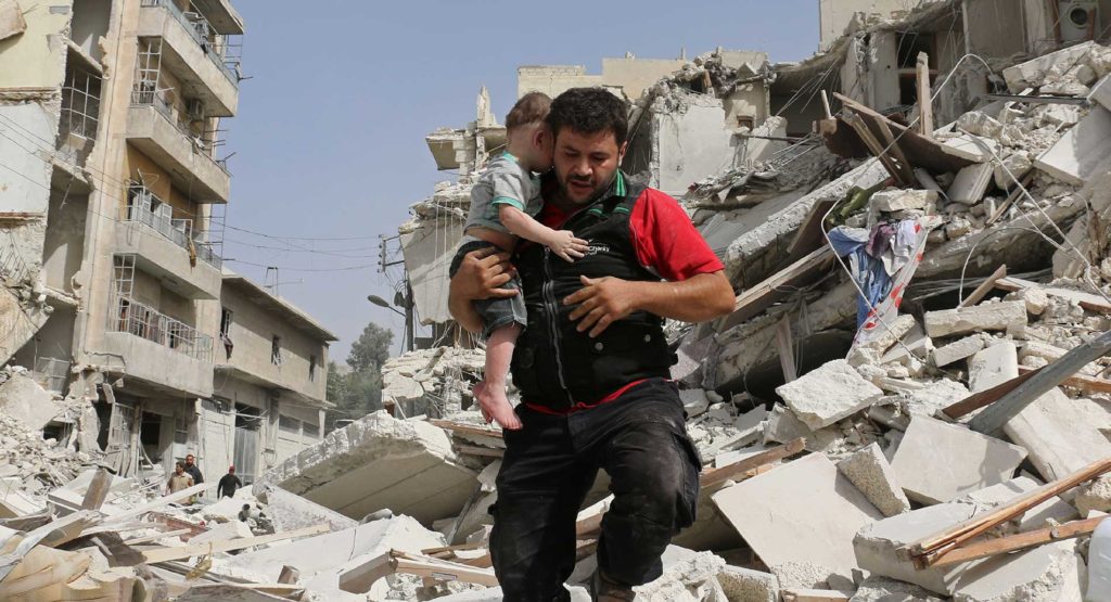 A man and his child behind a bombed building