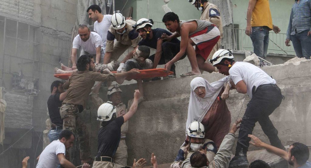 Syrian rescue workers and citizens evacuate people from a building following a reported barrel bomb attack by Syrian government forces.
