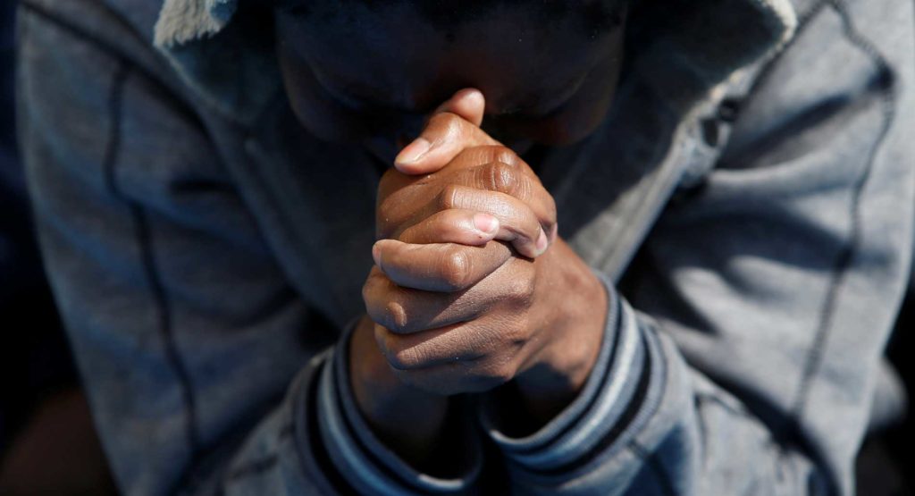 A man prays on the Migrant Offshore Aid Station ship Topaz Responder after being rescued off the coast of Libya