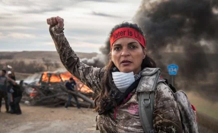 A Field Medic wearing camo and a red headband that reads: 