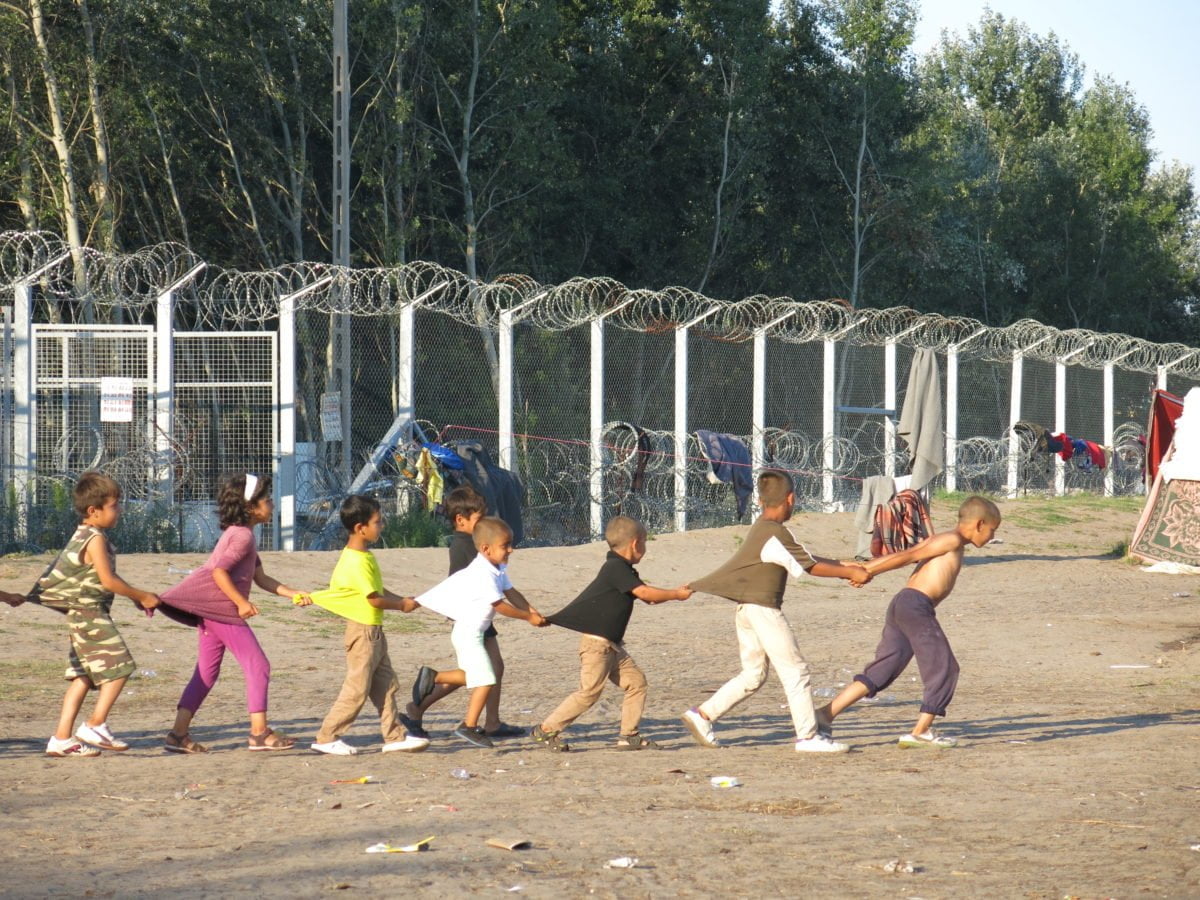 Child refugees playing in a line holding each other