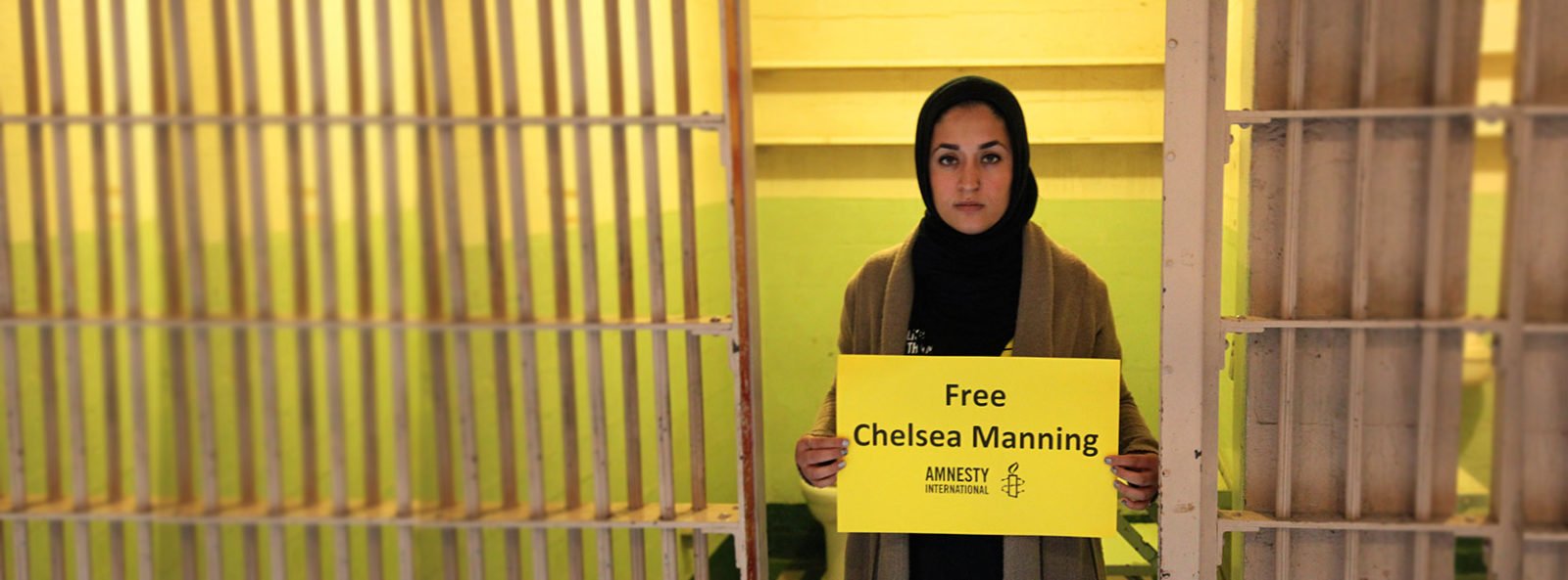 A woman holds a sign reading 'Free Chelsea Manning'. &copy; AI