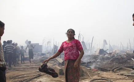 A Rohingya woman grieves after a fire gutted her family's shelter, Rakhine state, May 2016
