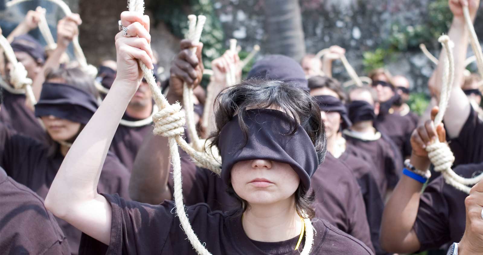 Amnesty protester wear blindfolds and hold a noose