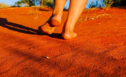 Walking barefoot on red sand dune