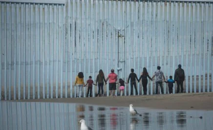 People facing a wall on the Mexico Border