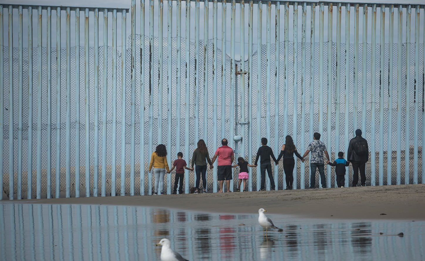 People facing a wall on the Mexico Border