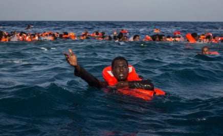 MAY 24: Refugees and migrants are seen swimming and yelling for assistance from crew members. © Chris McGrath/Getty Images