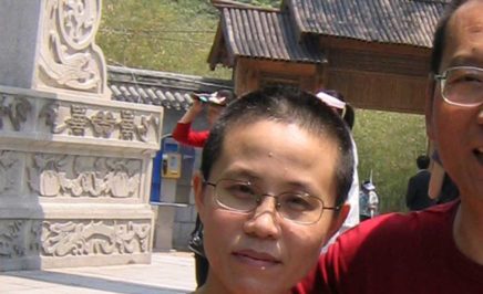 Liu Xia and Liu Xiaobo stand together, smiling, both in red T-shirts.