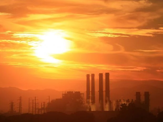 image of a factory with gas omissions pollution towers sunset