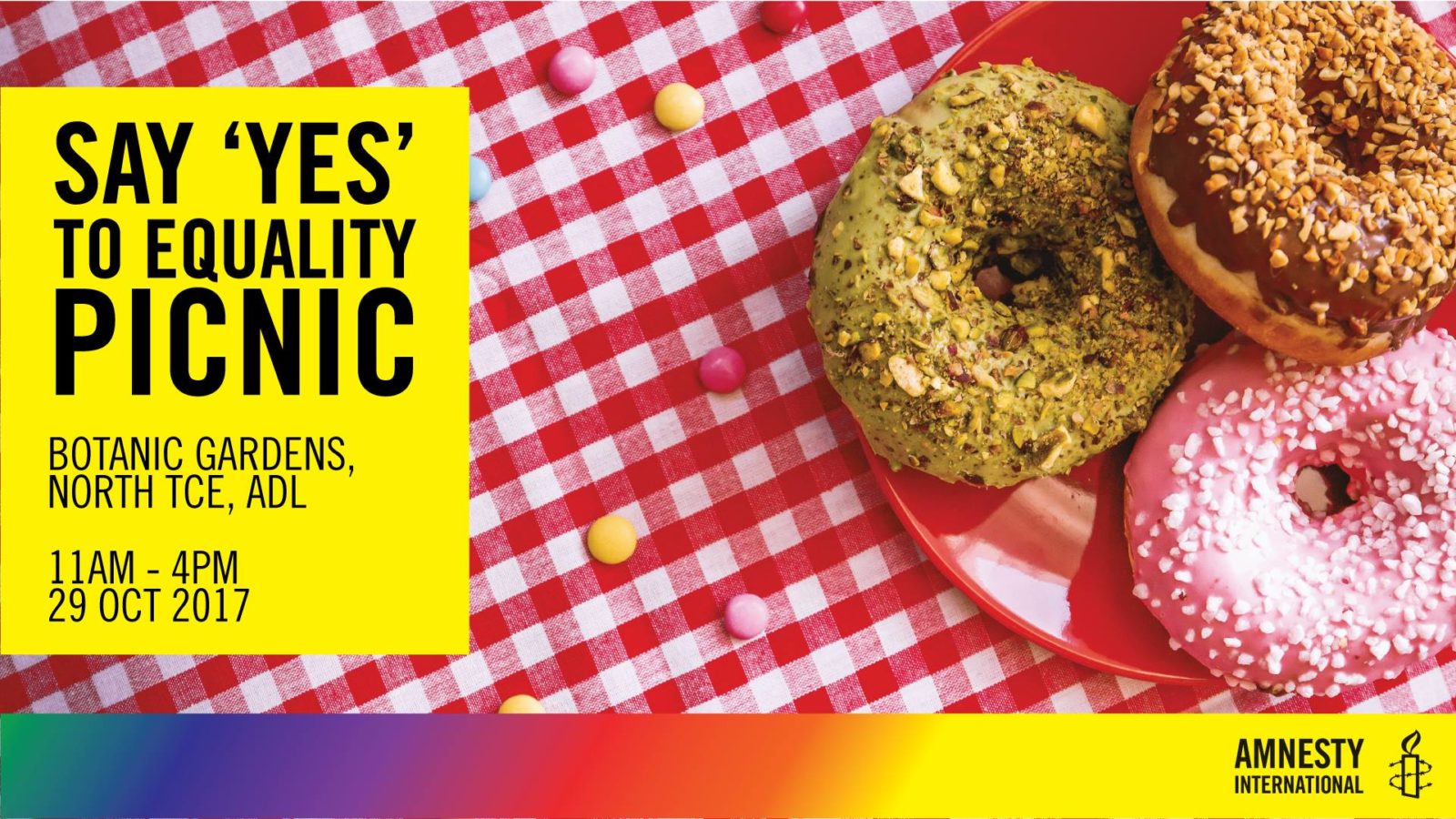 A checked table cloth with three donuts on with the title 'say yes to equality picnic'