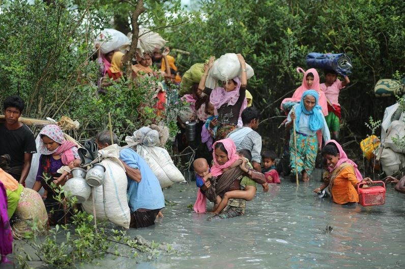 Rohingya Muslims walk through water after crossing the Myanmar border and Naff river to enter Bangladesh. © Getty Images