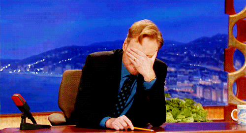An animated gif of US talk show host Conan O'Brien covering his eyes and shaking his head whilst interviewing a guest who is sitting off-camera.