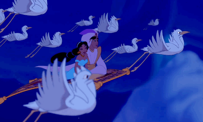 An animated gif of a scene from the Disney movie 'Aladdin'. The gif shows characters Aladdin and Jasmine flying through the air on a magic carpet surrounded by birds flying around them.