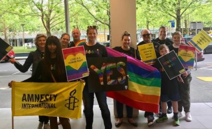Canberra activists holding rainbow flags and banners at a Marriage Equality Rally in Canberra