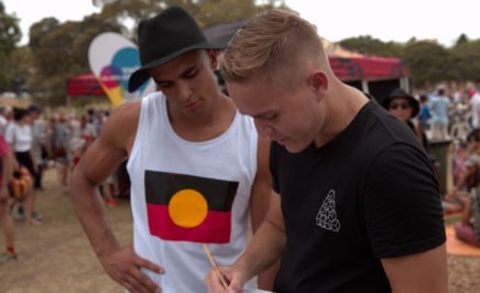 Two young Indigenous men signing an Amnesty petition at Yabun festival on Survival Day in Sydney