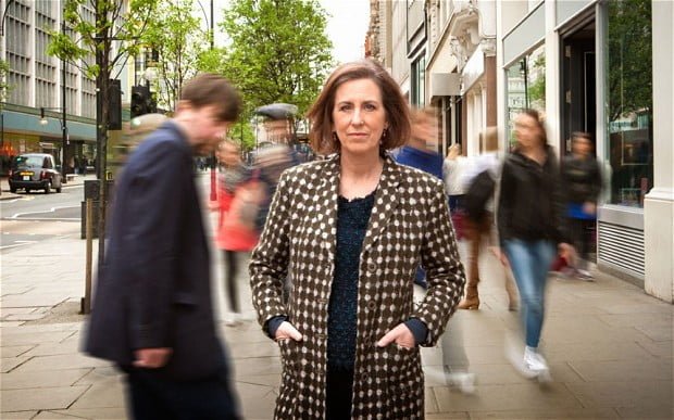 Presenter Kirsty Wark stands in front of blurred figures on the street