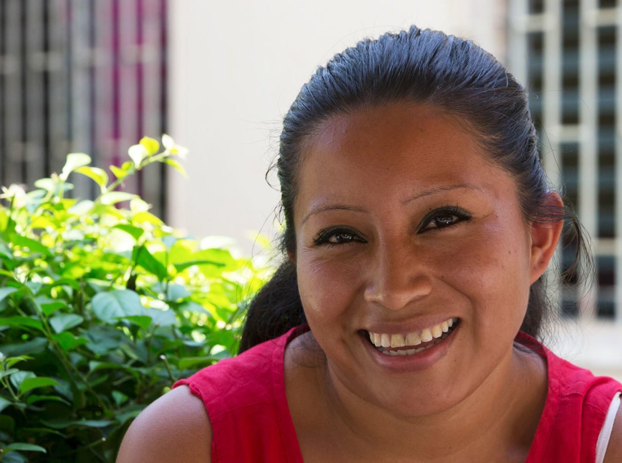 Portrait photo of Teodora Vasquez, jailed for ten years in El Salvador for having a miscarriage. She is in the prison, smiling towards the camera.,
