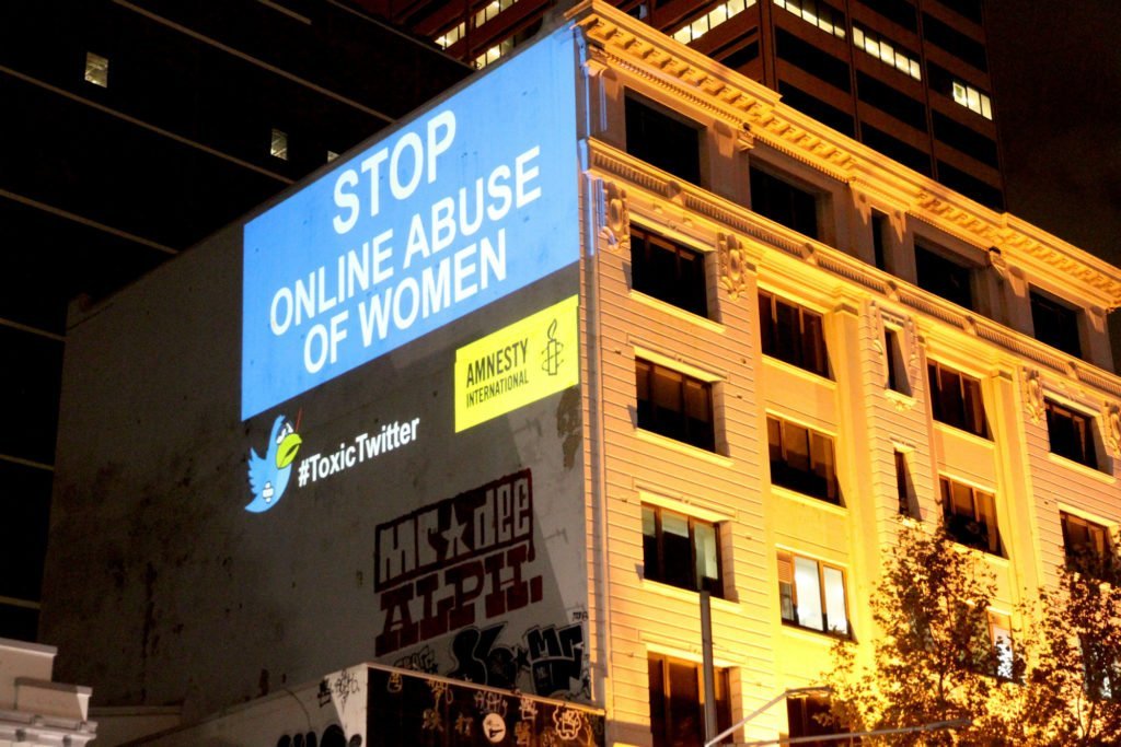 Projection on a building that says Twitter: Stop online abuse of women