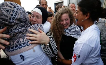Ahed Tamimi greeting friends with her mother following her release from prison in the West Bank