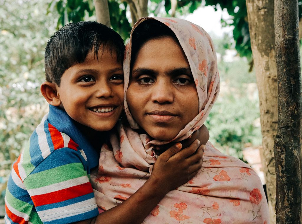 A Rohingya woman and her young son smile at the camera