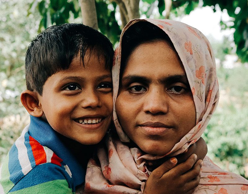 A Rohingya woman and her young son smile at the camera
