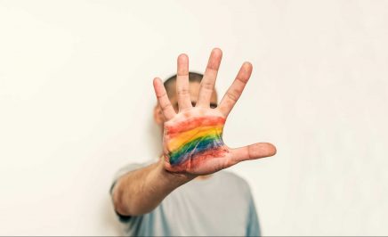 A hand with a pride flag painted on the palm. © iStock/ljubaphoto