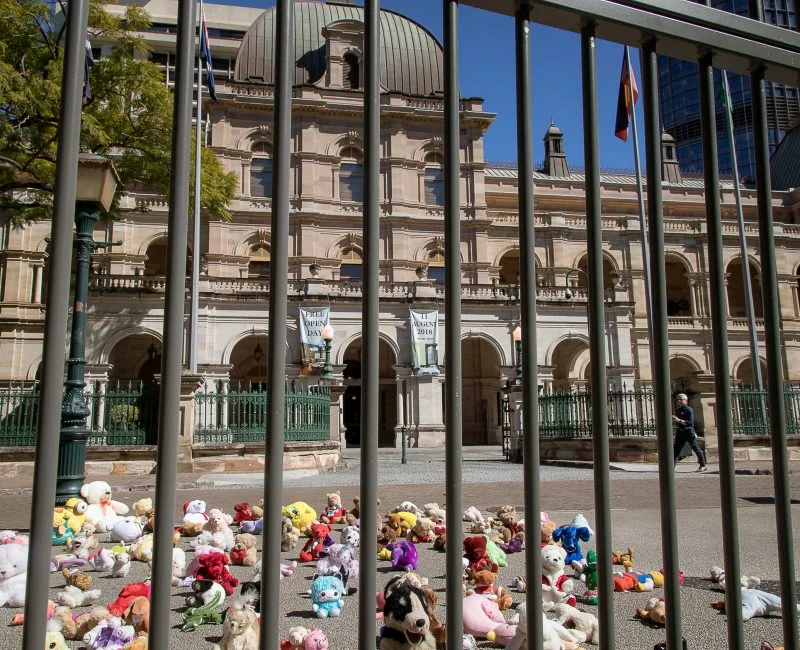 146 stuffed toys behind bars out the front of Queensland Parliament House. For each teddy there is a child under 14 behind bars in Queensland