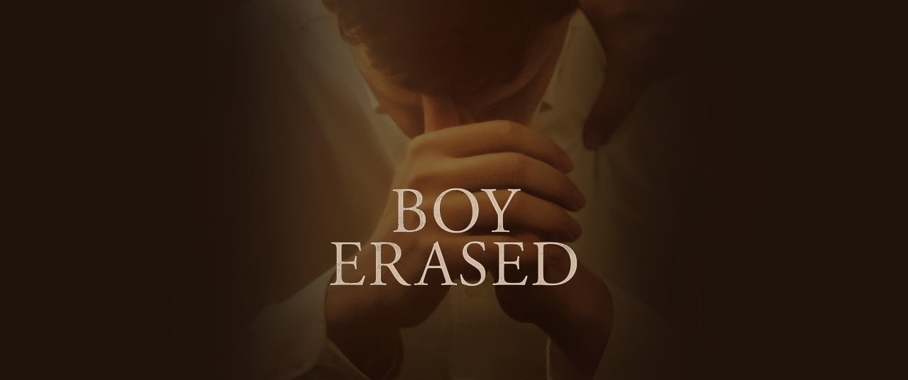 image of clasped hands in front of a yound mans face with the text 'boy erased'
